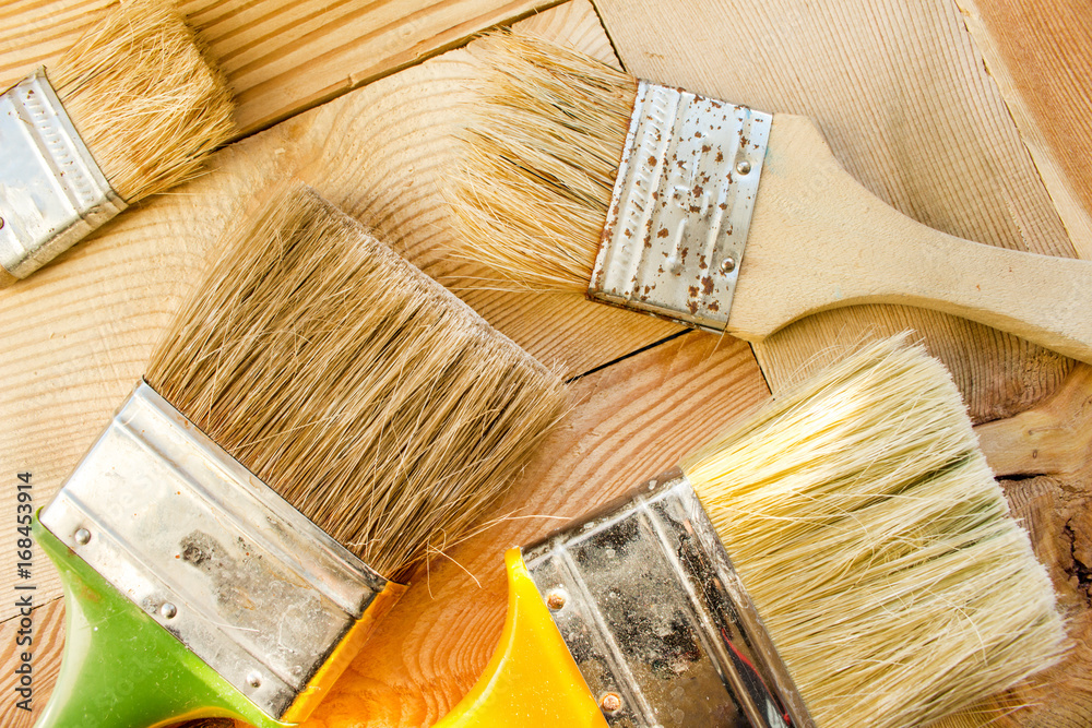 Wall mural Paint brushes on a wooden surface