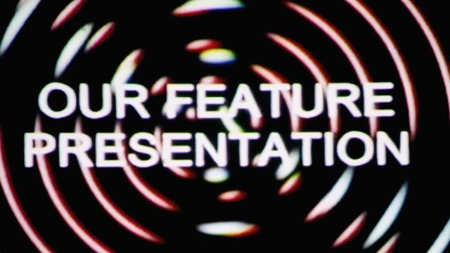 Vhs real projection: the text Our feature presentation appears over a set of spinning circles with a lens flare at the beginning. Grindhouse low-budget b-movie style.
