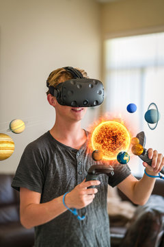 A teenage student wearing a virtual reality headset to study science.