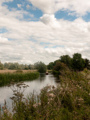 river side scene outside with row boat in distance of country