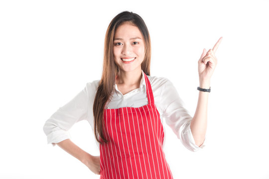Portrait of Smiling beautiful young Asian woman wear red apron and hand pointing with copy space for your text or advertising isolated on white.