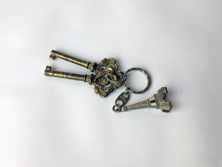 Two metal keys and Eiffel Tower key chain isolate on white background. the key is a small piece of...