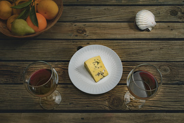Wine and cheese testing, color grade COLD Red wine, cheese, fruits on outdoor table. 