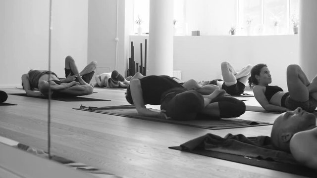 Group of people doing yoga asanas in studio