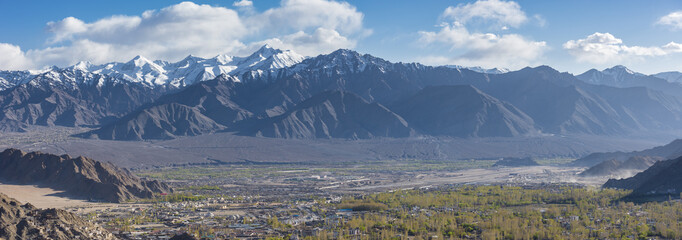 Long mountain range with blue sky cast over the city of Leh Ladakh