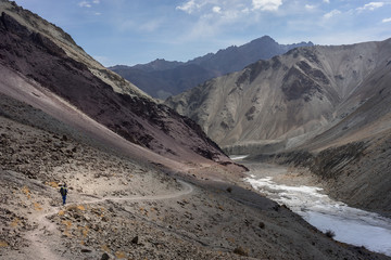 A man treks along the frozen river in Markha valley trekking route, Leh Ladakh, India