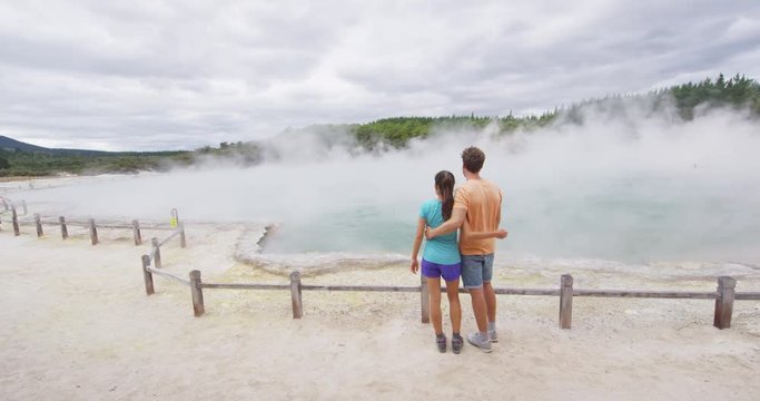 New Zealand tourists. Couple on travel at Champagne pool at Wai-O-Tapu pools Sacred Waters. Tourist attraction in Waiotapu, Rotorua. Active geothermal area, Okataina Volcanic Centre Taupo, New Zealand