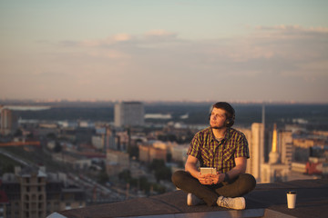 Man is listening to music on roof.