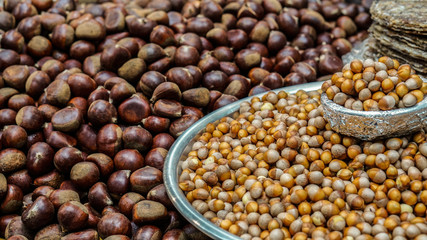 Roasted chestnut, pine nut peeled and corn on street food stall. Autumn food of Asia