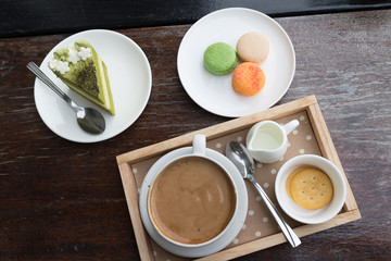 hot coffee breakfast set with green tea cake and fresh .macaroon in cozy outdoor cafe