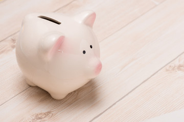 A pink piggy bank on wooden table.