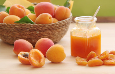 Fresh apricot, dried apricots and apricot jam. Fresh fruit in a wicker basket on background. Close up view.