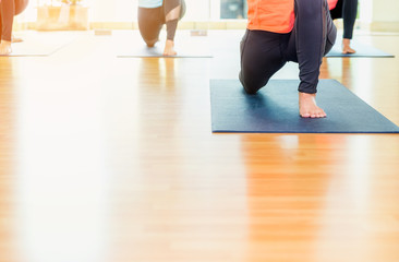 Fototapeta na wymiar Close up feet of yoga class stretching on mat at studio classroom,healthy lifestyle sport.