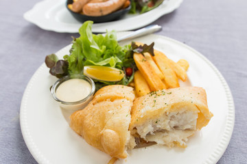 fish and chips served on a white plate