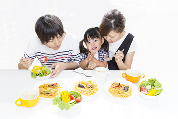 幼い女の子と家族3人で一緒に食事するイメージ