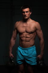 Fototapeta na wymiar Fitness man with shirtless body posing in gym