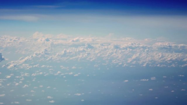 The view from the airplane window many small clouds and blue sky.