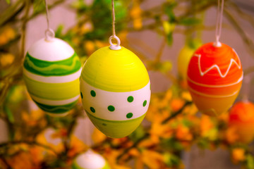 brightly painted eggs hanging in a tree