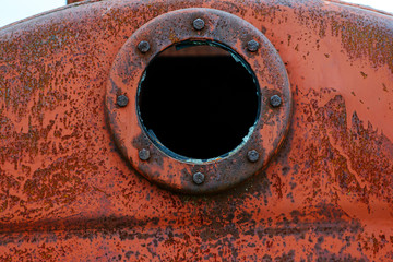 Close up background of rusty metal tank with rusty circular hole