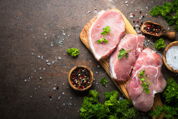 Fresh meat. Raw pork steak. Top view on stone table. Food background.