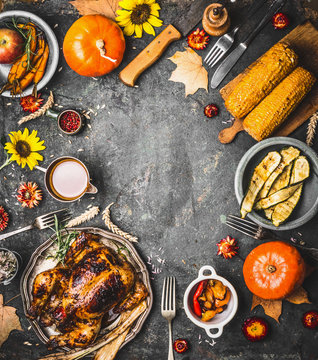 Thanksgiving dinner background with roasted turkey , sauce , pumpkin and dishes of  autumn vegetables on rustic background, top view, frame