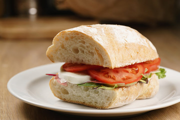 ciabatta sandwich with speck, mozzarella and vegetables
