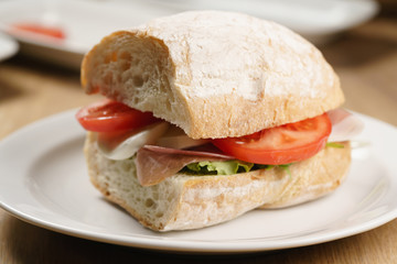 ciabatta sandwich with speck, mozzarella and vegetables