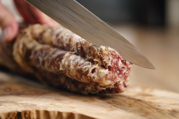 closeup shot of slicing salami with knife