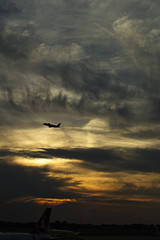 Aeroplane (airplane) taking off (Dusseldorf Airport) at sunset, Germany.