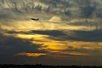 Fototapeta na wymiar Aeroplane (airplane) taking off at sunset.