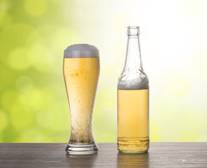 Glass of beer with bottle on the table.