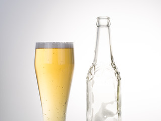 Glass of beer with bottle isolated on white. Closeup.