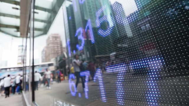 Time lapse of Stock market quotes with city scene reflect on glass