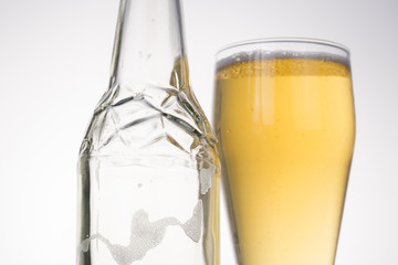 Glass of beer with bottle isolated on white. Closeup.