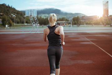 A woman runs through the stadium. A healthy way of life.