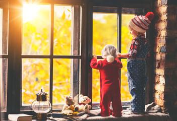Children brother and sister admiring window for autumn