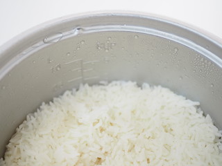 Thai local traditional boiled white jasmine rice in aluminum cooker pot, top view, half