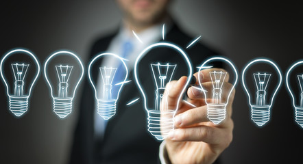 Businessman drawing a sketch lightbulb with a pen