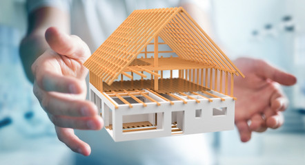 Businessman holding 3D rendering unfinished plan house in his hand