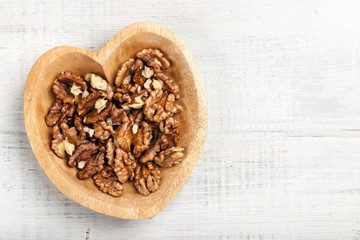 Walnuts in heart shaped wooden bowl