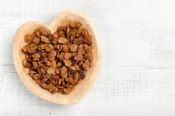 Raisins in heart shaped wooden bowl