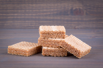 Waffles with sweet filling on a wooden background.