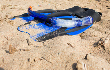 swimming snorkel and fins lying on the sand