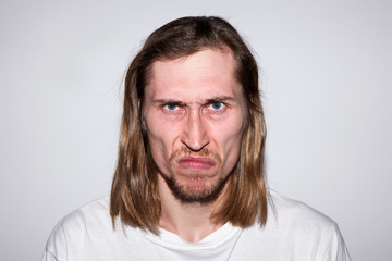 Embittered young man on gray background. Insult conversation. Offended casual male, bad news for...