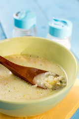 Wooden spoon in the soup with vegetables and meat on the blue wooden table