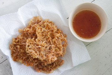 Fried prawn balls on Tissue with Sauce on white table.