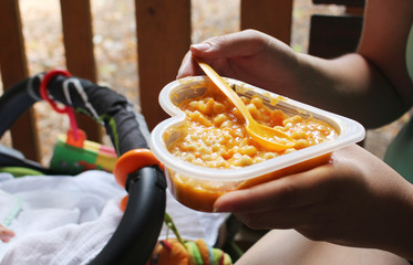 Mother feeds her baby with a healthy meal