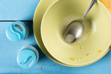 Flat lay above domestic soup bowl with metal spoon on the table with selective focus
