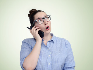 Young girl in glasses emotionally talking on telephone