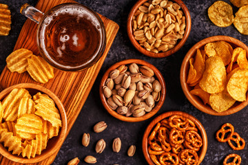 Beer with snacks on stone background.
